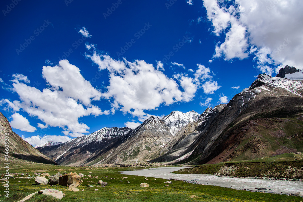 Landscape of stones and grass field with blue sky, India