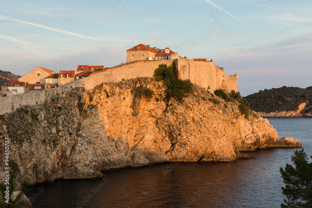 City Walls in Dubrovnik, Croatia, colored orange by sunset.