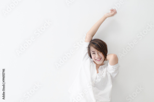 Motion blur happy Asian woman sitting on the bed, woke up and st