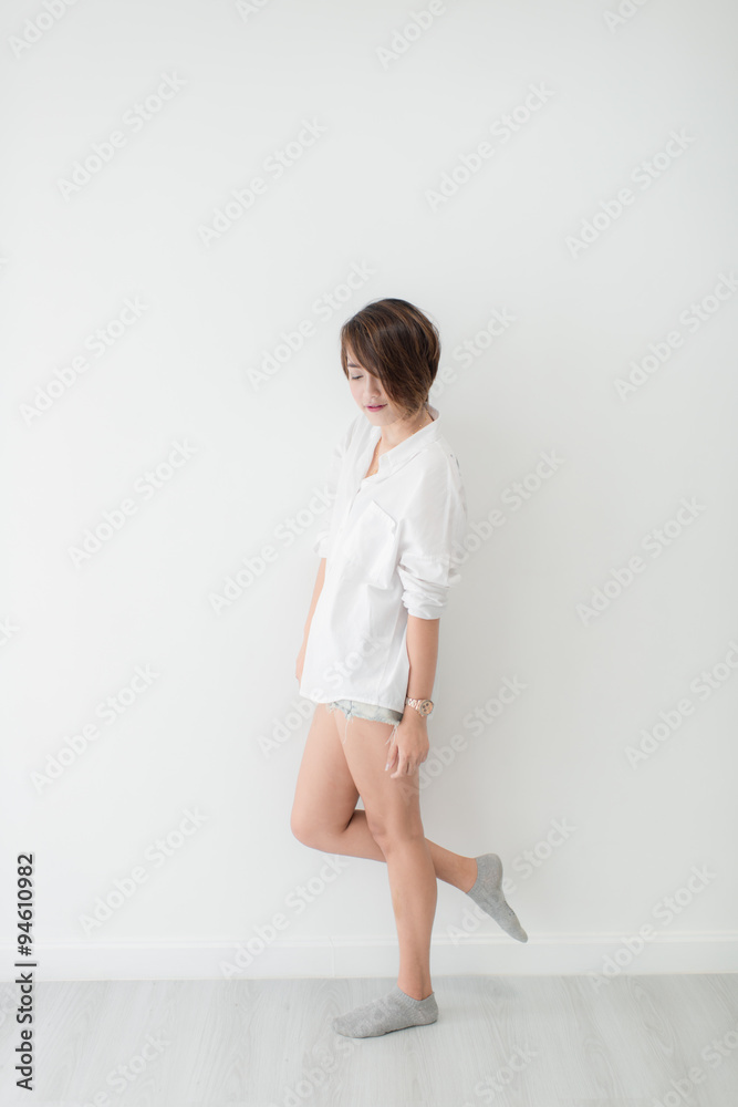 attractive asian woman standing on floor with white wall. attractive asian woman standing on floor with white wall.