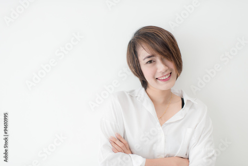 attractive asian woman standing on floor with white wall.
