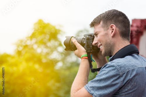 photographer with professional digital camera taking pictures in