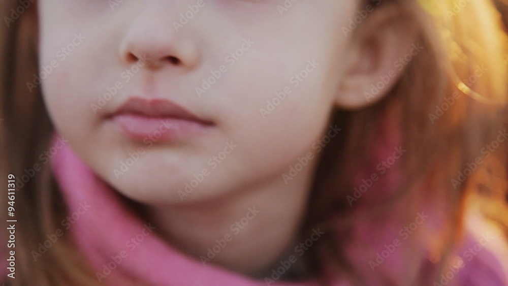 a little girl eating an apple at sunset. close-up a little girl eating an apple at sunset. close-up