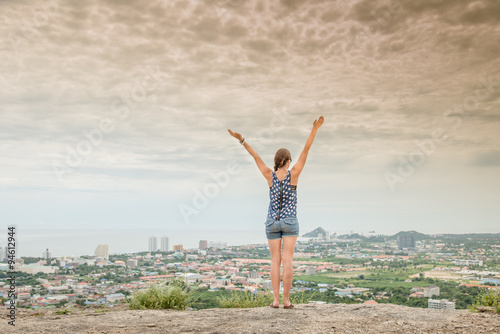 Young lady hiker enjoying view point from top of a mountain