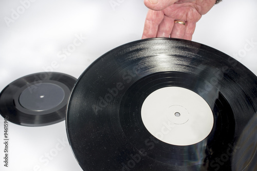 A vinyl record on the hands of a man, on white background