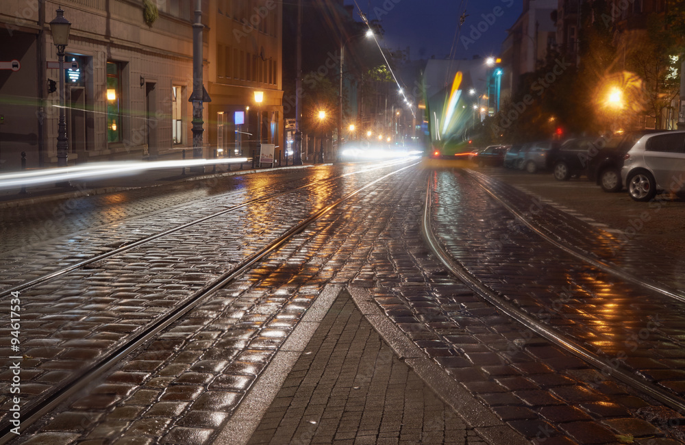 Rails of a tram on a cobblestone street at night in Poznan. Rails of a tram on a cobblestone street at night in Poznan.