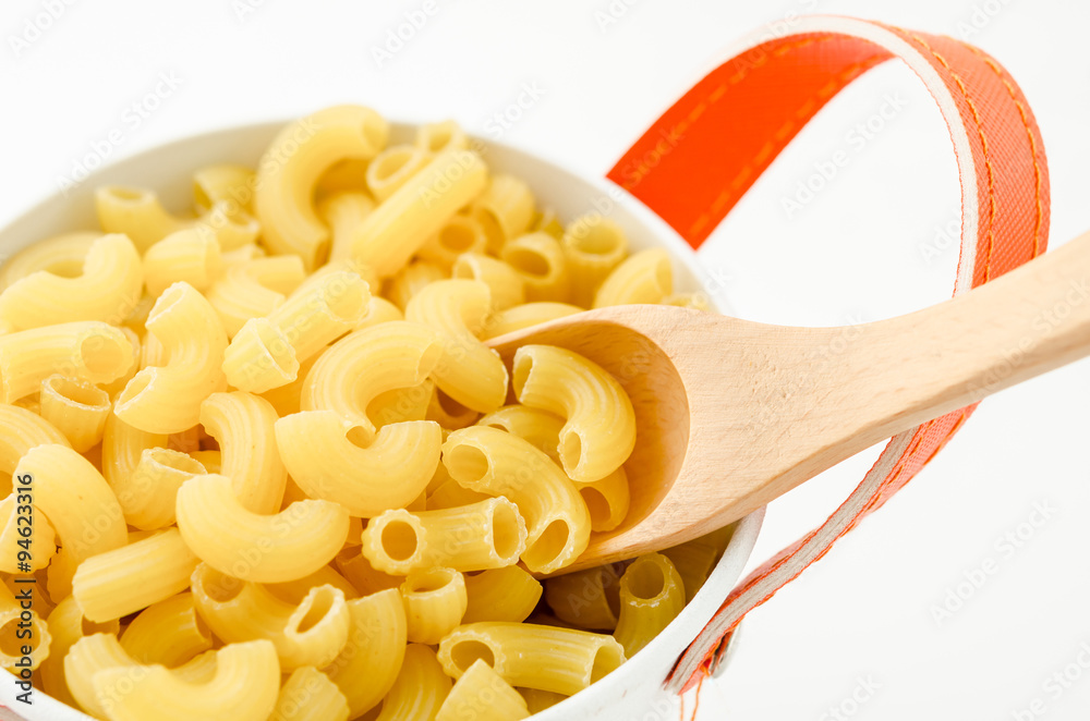 Raw dry elbow macaroni with wooden spoon. Stock Photo Adobe Stock
