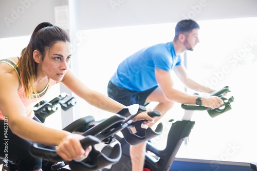 Man and woman using cycling exercise bikes