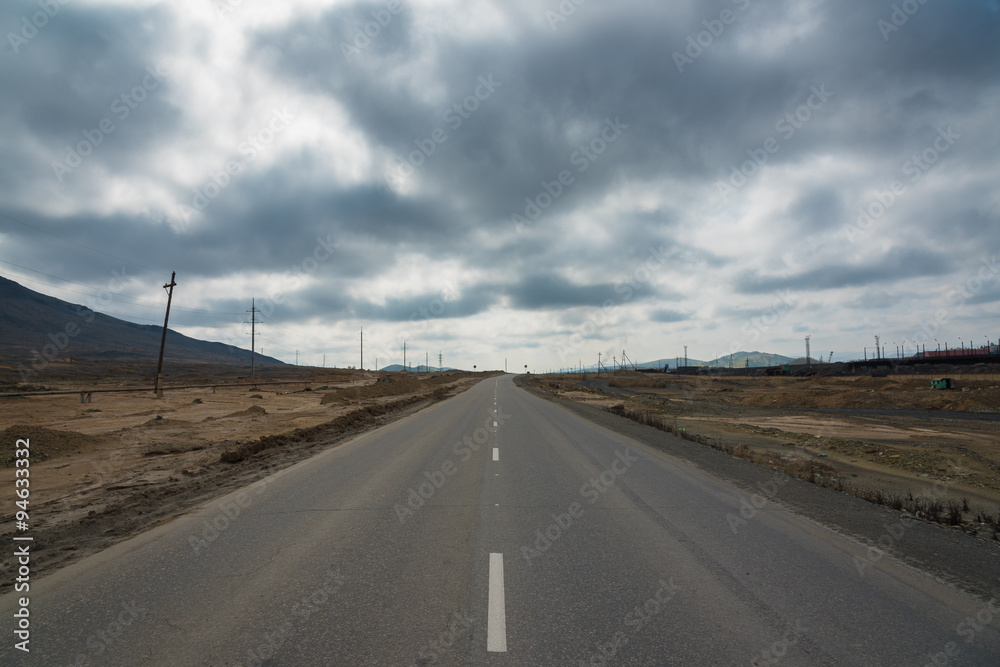 Asphalt road between fields  trees