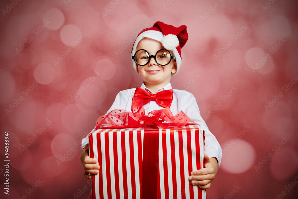 Kind als Weihnachtsmann mit Geschenk Stock Photo | Adobe Stock