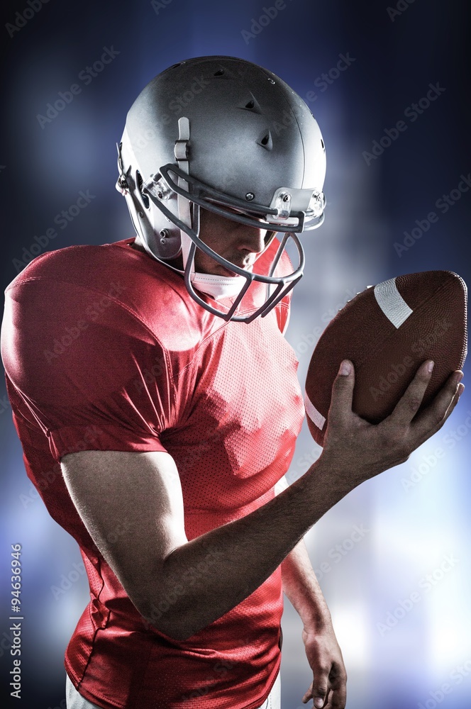 Composite image of american football player looking at ball 