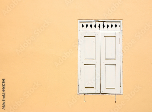 old White window with yellow wall background
