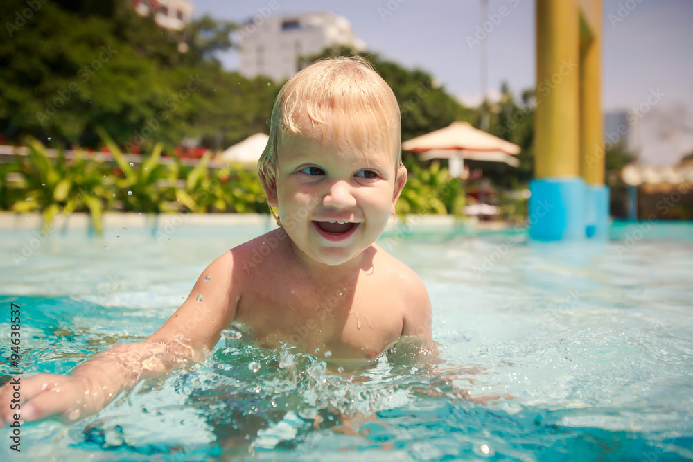 closeup small blonde girl smiles plays in hotel swimming pool