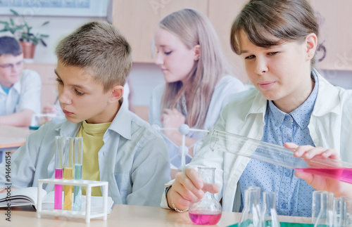 Schoolchildren and teacher in science class photo