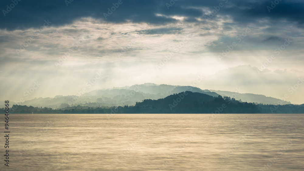 Grandiose panorama of Lake in Switzerland.  Sun rays play light and shadow.