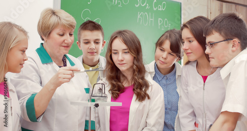 Schoolchildren and teacher in science class photo