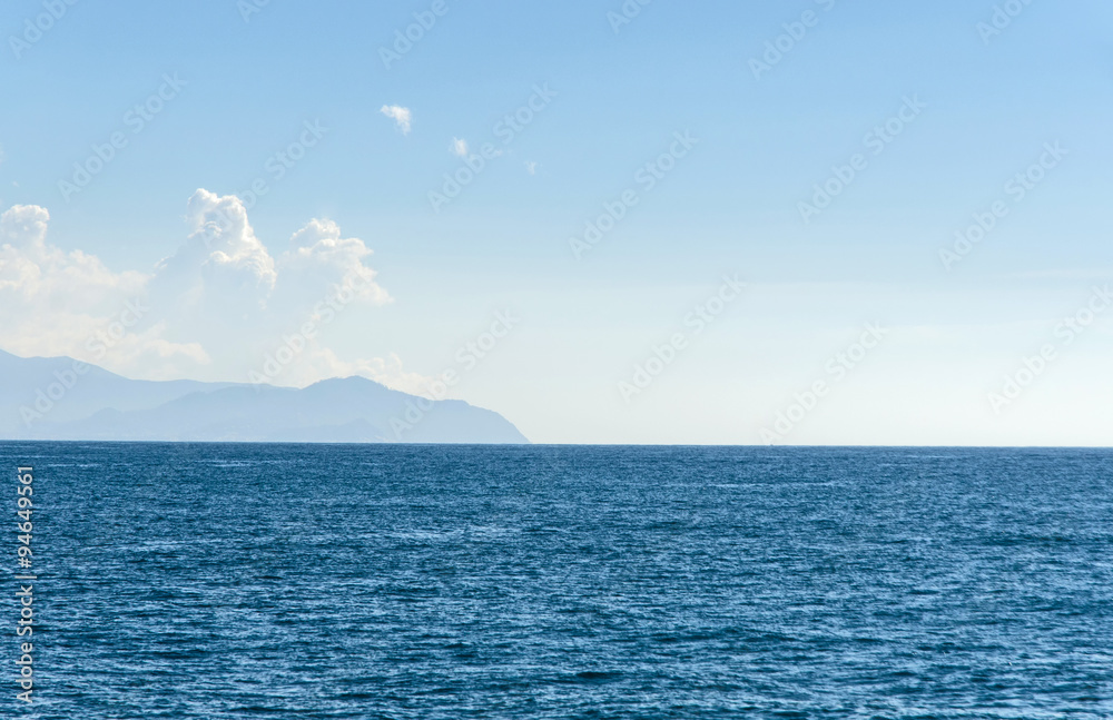 islands with mountains visible far away through the haze on a beautidul sunny day on teh sea