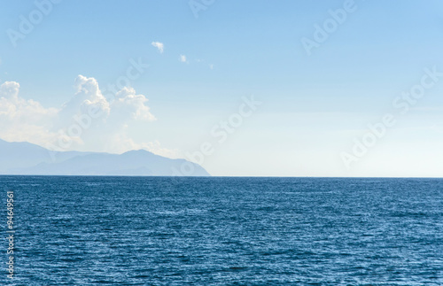 islands with mountains visible far away through the haze on a beautidul sunny day on teh sea