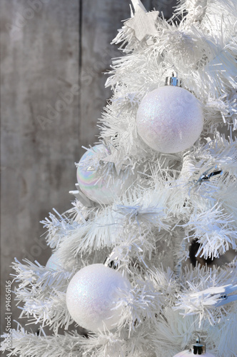 boules blanches sur sapin blanc de Noël fond bois