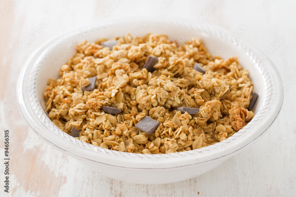 cereals with chocolate on white bowl on white wooden background cereals with chocolate on white bowl on white wooden background