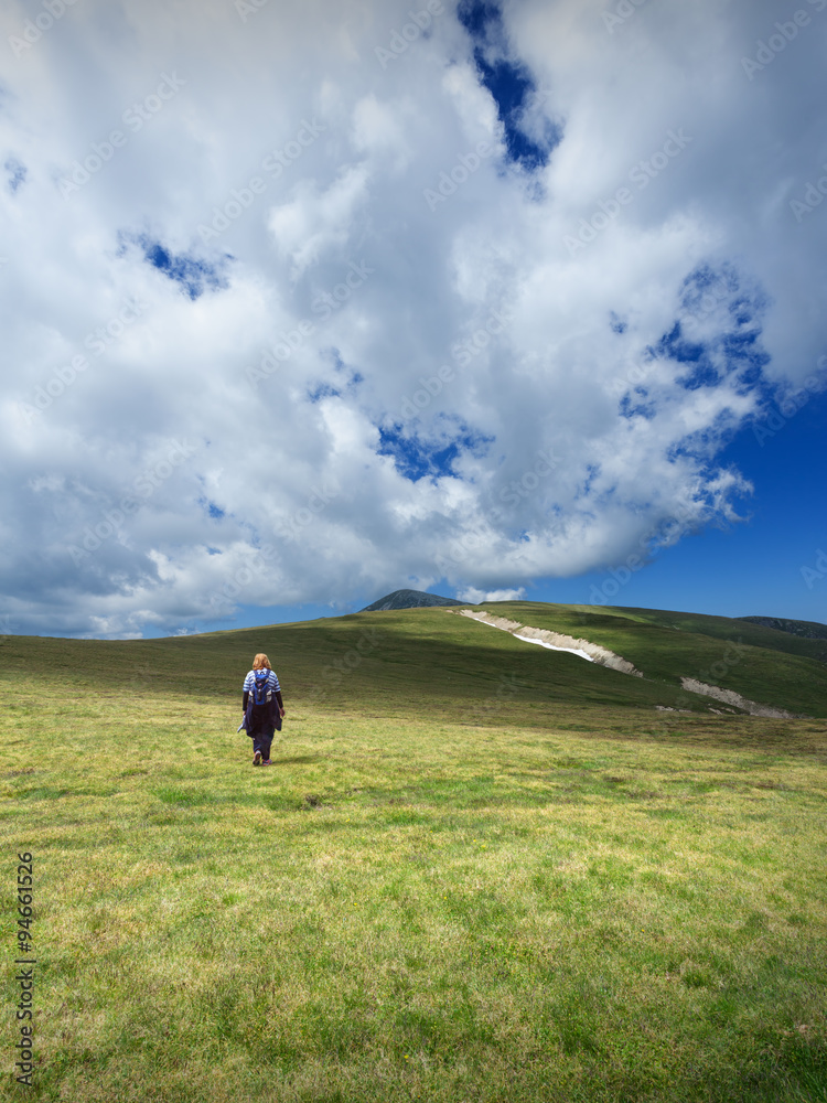 Woman hiking solitude on mountain meadow Woman hiking solitude on mountain meadow