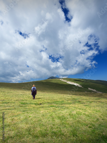Woman hiking solitude on mountain meadow