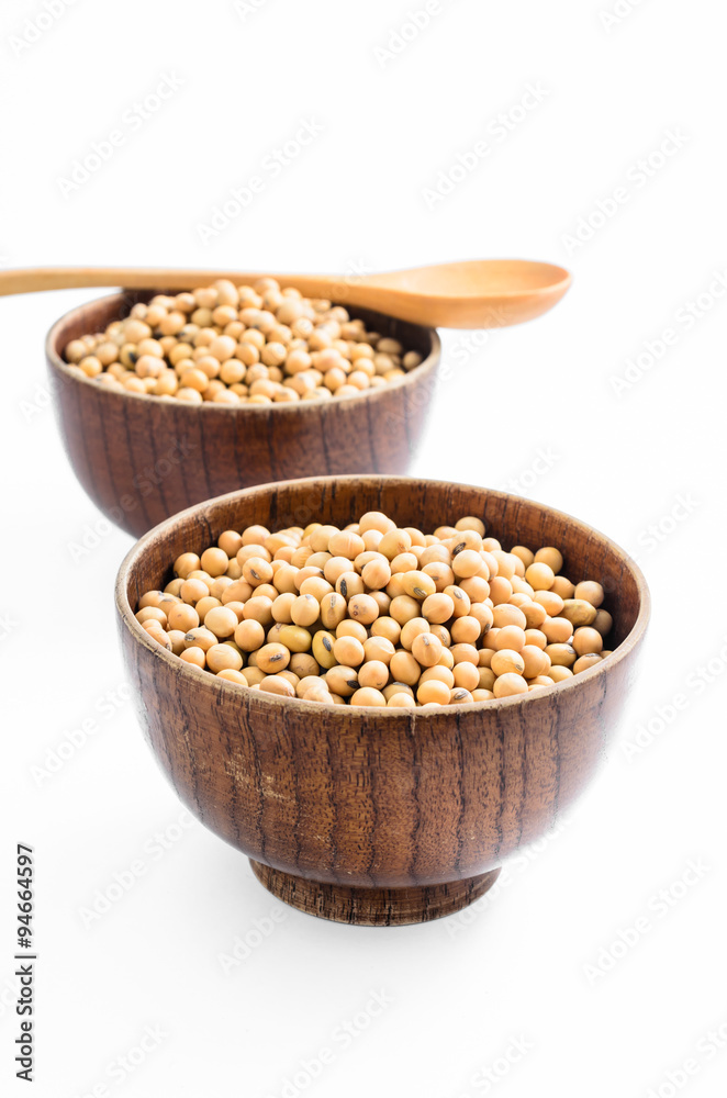 soybeans in wooden bowl with wooden spoon isolated on white background..