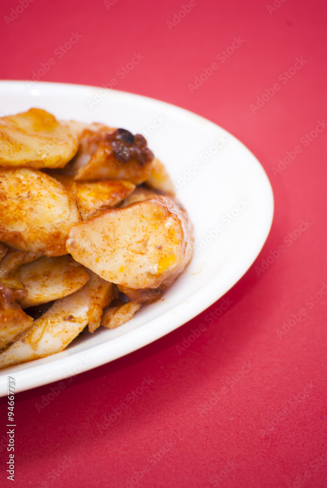 Octopus with paprika on a white plate, also known as Galician oc