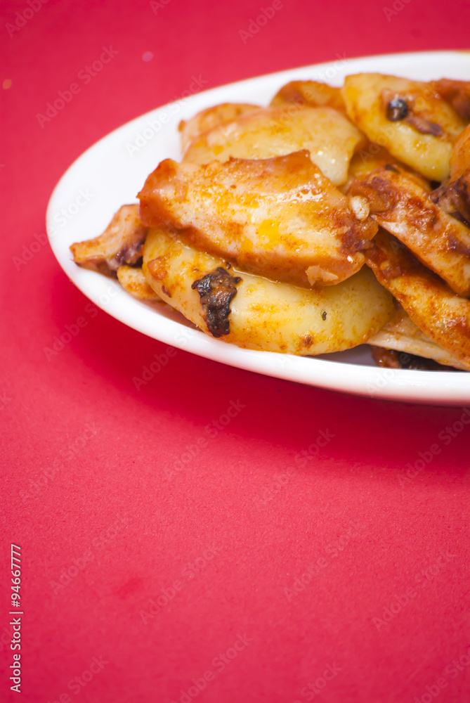 Octopus with paprika on a white plate, also known as Galician oc