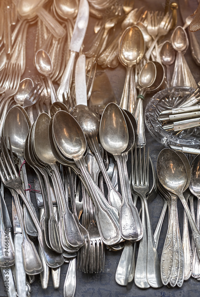 bunch of old silver ware on a flea market