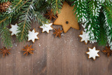 wooden background with fir branches and cookies, top view