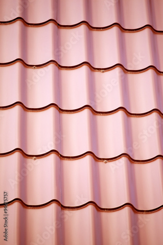 Construction material. Fragment of red metal roof as background closeup