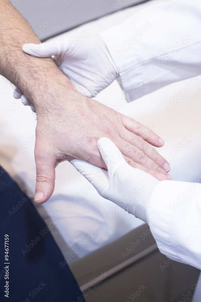Obraz premium Dooctor surgeon examines patient hand fingers wrist injury