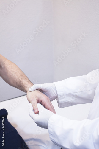 Dooctor surgeon examines patient hand fingers wrist injury