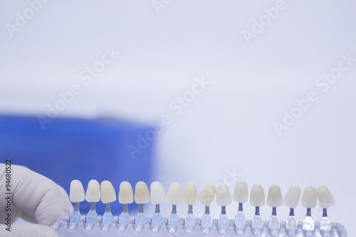 Dental nurse holding implant and crown tooth color guide
