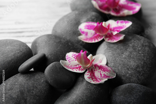 Spa stones and orchids on wooden background