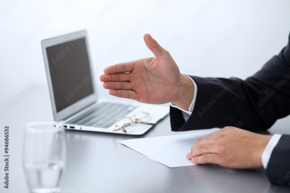 Close-up of businessman at the table giving a hand Close-up of businessman at the table giving a hand
