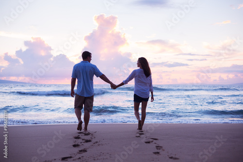 Lovers Walking on the Beach at Sunset on Vacation photo