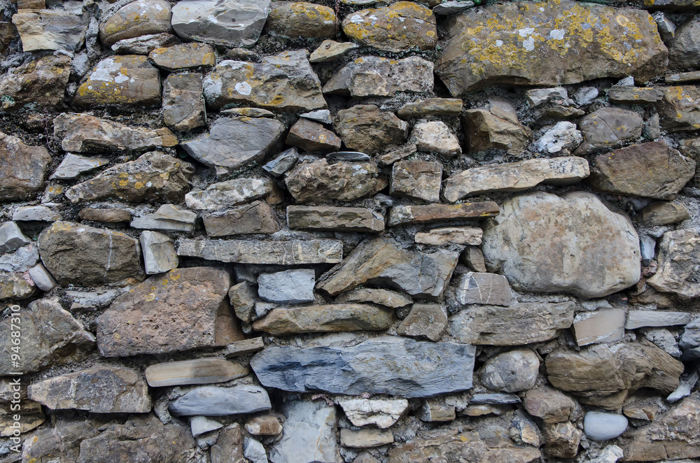 close-up of the weathered  rocks and stones making up an old fence