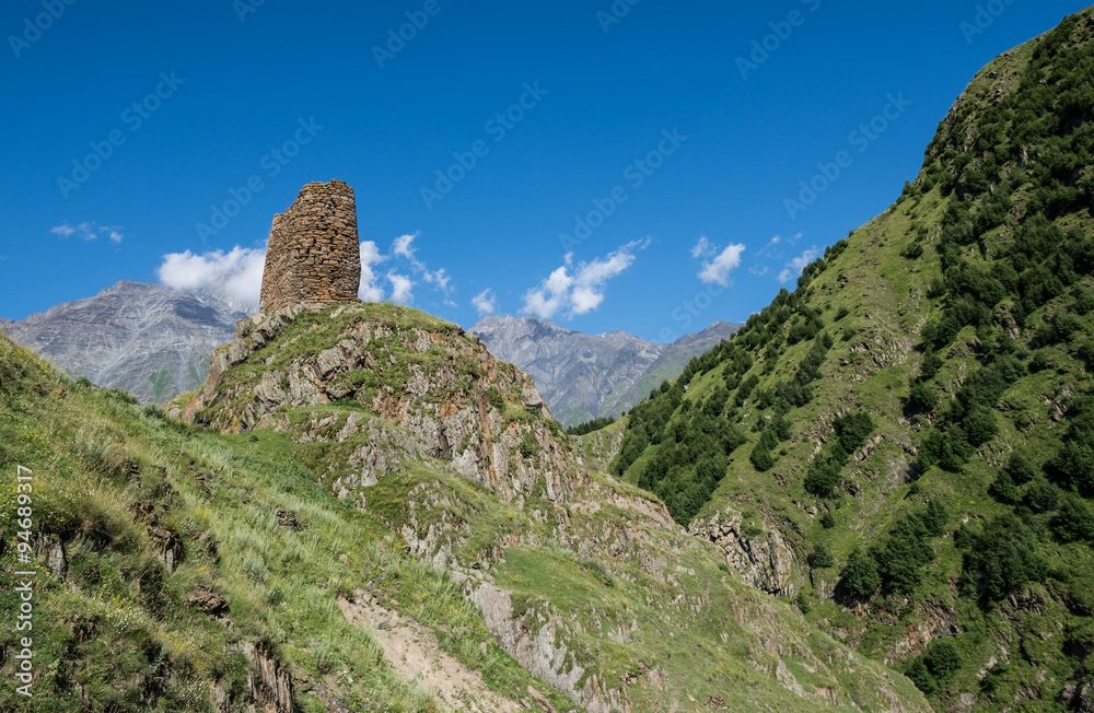 old fortified tower on the way from Stepantsmida town to Gergeti Trinity Church, Greater Caucasus Range in Georgia