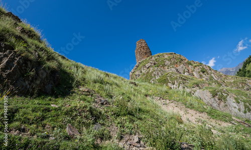 old fortified tower on the way from Stepantsmida town to Gergeti Trinity Church, Greater Caucasus Range in Georgia photo