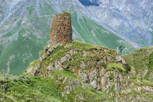 old fortified tower on the way from Stepantsmida town to Gergeti Trinity Church, Greater Caucasus Range in Georgia photo