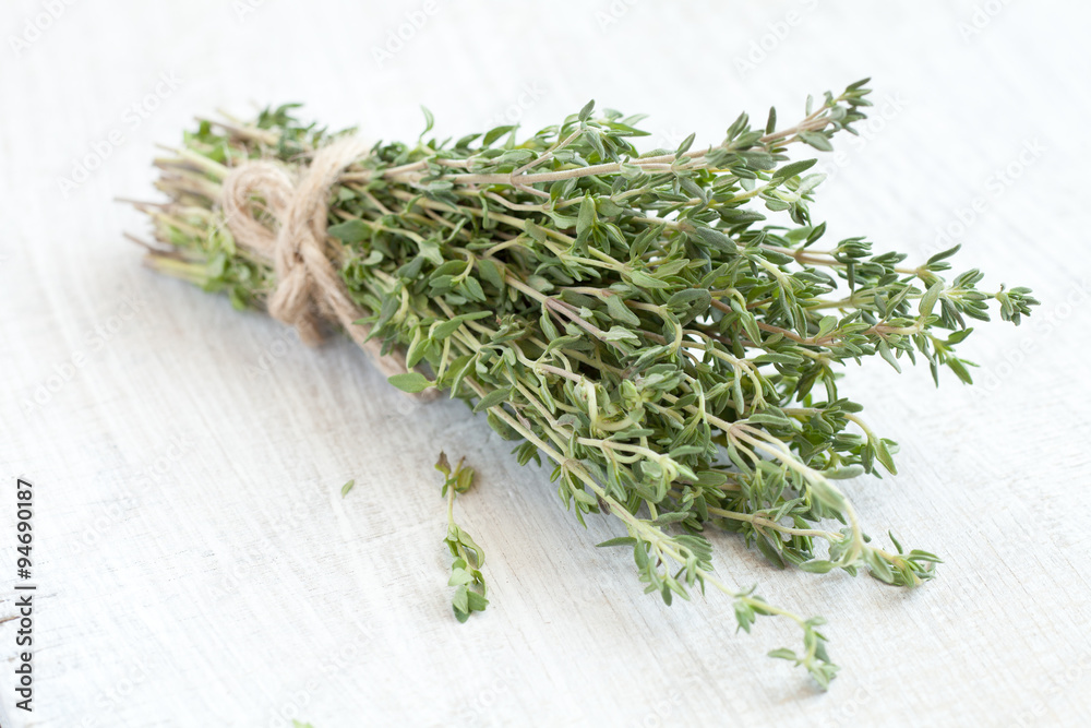 bundle of thyme on a white wooden background bundle of thyme on a white wooden background