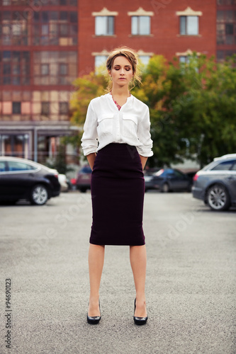 Young fashion business woman standing on the car parking