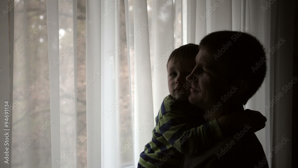 Silhouette of happy father holding his son on his hands and looking in window
Silhouette of happy father holding his son on his hands and looking in window