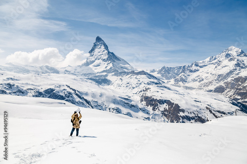 A man carry the snow ball with the background of Matterhorn.
