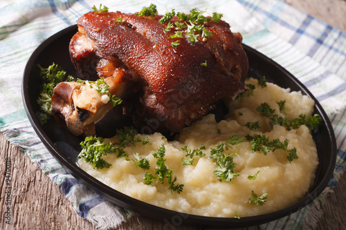 Baked pork shank and mashed potatoes closeup. horizontal
 photo