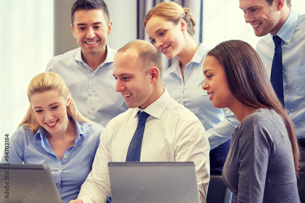 smiling business people with laptop computer