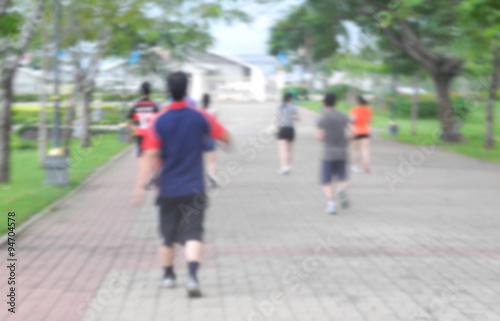 Blurred background of people running in park