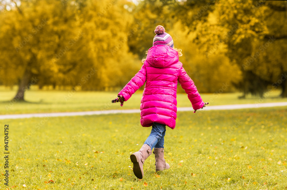 Fototapeta premium happy little girl running in autumn park